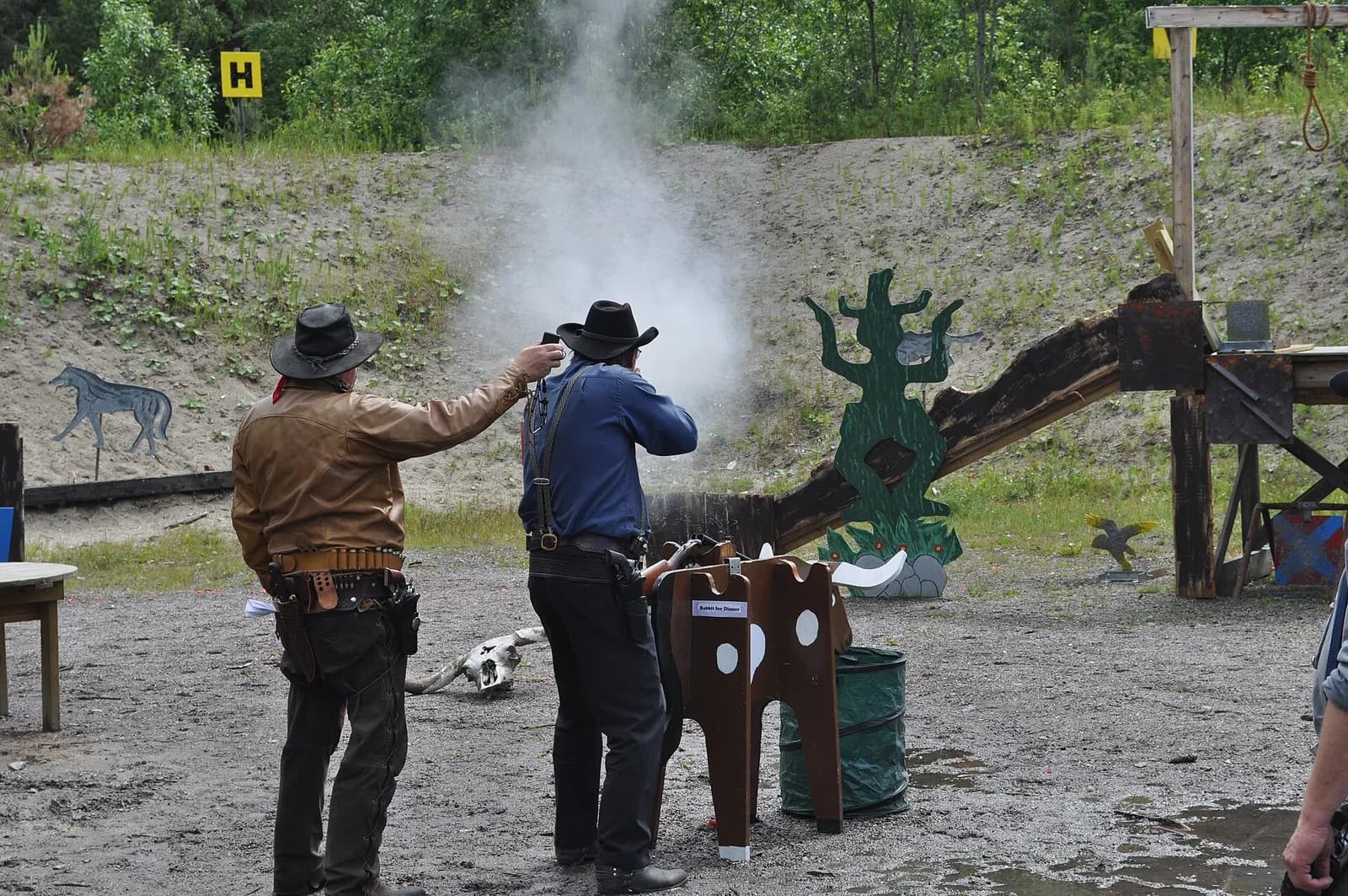 Cowboy action shooter in period costume with lever-action rifle